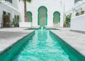 a swimming pool with a large pool of water in the middle of it at Hotel & Spa La Residencia Puerto in Tarifa