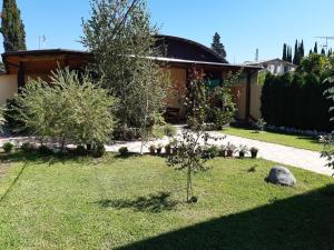 a garden with trees and a house in the background at Guest House Eleonora in Tsandrypsh