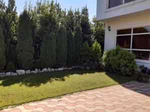a garden in front of a house at Guest House Eleonora in Tsandrypsh