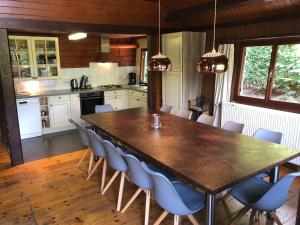 een keuken met een grote houten tafel en stoelen bij Chalet Grand Coo in Stavelot