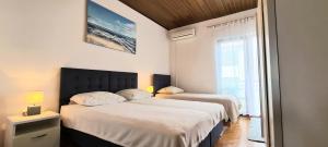 1 dormitorio con 2 camas y ventana en Solaris Apartments, en Šibenik