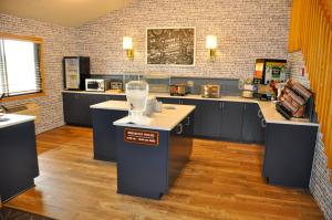 a large kitchen with blue cabinets and a counter top at AmericInn by Wyndham Clear Lake in Clear Lake