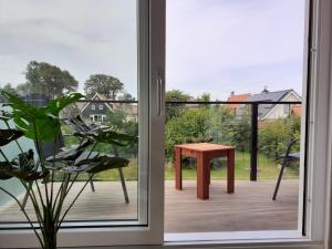 a sliding glass door with a table on a deck at de Pastorie in Hollum