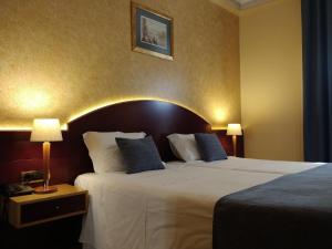a hotel room with a large bed with blue pillows at Hotel Internacional Porto in Porto