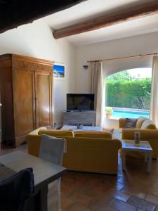 a living room with a couch and a tv at Villa dans le LUBERON à 2 km de LOURMARIN in Lauris