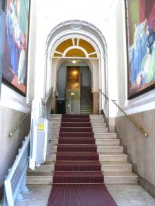 a flight of stairs in a building with paintings at Cambridge Hotel in Rome