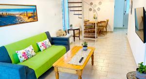 a living room with a green couch and a coffee table at JustSmile - Seaview Maisonette in Latchi in Lachi