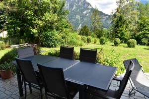 een tafel en stoelen op een patio met bergen op de achtergrond bij Ferienwohnung Isabell in Ebensee