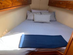 a bed in a small room with a blue blanket on it at BARCO PURAVIDA in Vigo