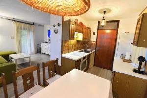 a kitchen and living room with a table and a kitchen and a dining room at Holiday Home Davča in Cerkno