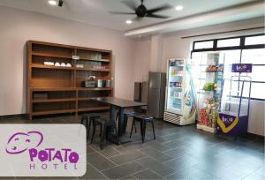 a restaurant with a table and a refrigerator at Potato Hotel in Taiping
