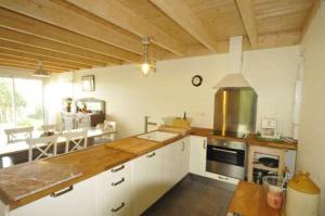 eine große Küche mit weißen Schränken und einem Herd in der Unterkunft Un Jardin en Pente Douce in Locquénolé