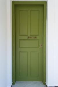 a green door with a handle in a hallway at Studios Marianna in Skiros