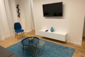 Una sala de estar con una mesa y un televisor en una pared. en Stylist and cosy appartement in Montparnasse, en París