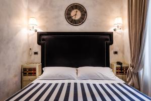 ローマにあるMDM Guesthouseのベッドルーム1室(壁に大きな時計が付いたベッド1台付)