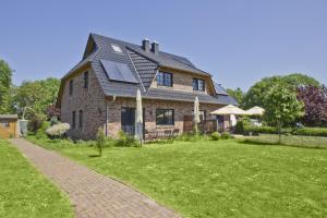 ein großes Backsteinhaus mit einem Rasenhof in der Unterkunft Ostseehaus Odin Doppelhaushälfte in Wiek auf Rügen 
