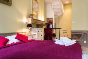 a bedroom with a large purple bed with red pillows at Appartement - Petit Buffon in Dijon