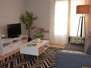 een woonkamer met een bank en een tv bij Charmant T2 Port de Vannes in Vannes