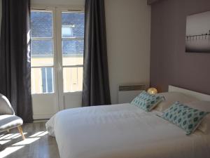 een slaapkamer met een bed en een groot raam bij Charmant T2 Port de Vannes in Vannes