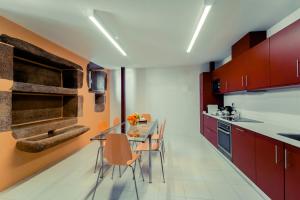 a kitchen with red cabinets and a table and chairs at Casas do Prior in Trevões