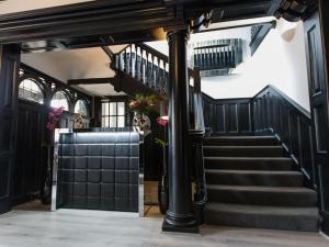 a staircase in a building with black walls and a stair case at Verve Hotel in Bedford