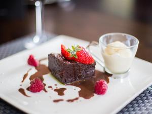 a piece of chocolate cake with strawberries and a glass of milk at Verve Hotel in Bedford