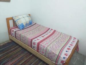 Una cama con una manta y una almohada. en November Camp, en Dahab