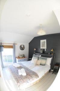 1 dormitorio con 1 cama grande con almohadas blancas en Victoria Inn en Penzance