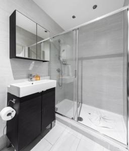 y baño con ducha, lavabo y ducha. en Vilenza Hotel en Londres