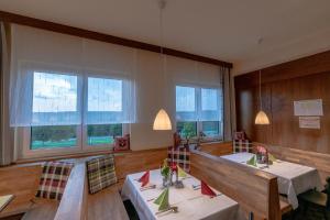 a dining room with tables and chairs and windows at Gasthof Sonnenterrasse - 24h Self-Check-in in Litzelsdorf