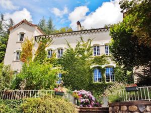 una casa con un jardín delante de ella en Villa Aimée Luxury Apartments with Heated Pool, en Vals-les-Bains