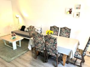 comedor con mesa, sillas y sofá en Cosy 74m2 apartment close to Paris, en Houilles