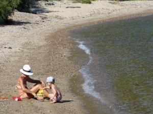 a couple of people sitting on a beach at Résidence U Paviddonu in Porto-Vecchio