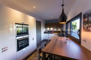 a kitchen with a wooden table and a large window at Les Catalons in Sévrier