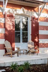 twee stoelen op een veranda van een huis bij VILLA LES OMBREES in Arcachon