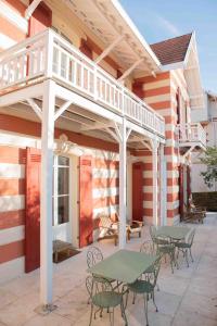 een patio met een terras en tafels en stoelen bij VILLA LES OMBREES in Arcachon