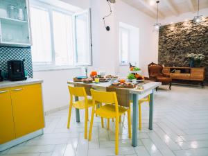 a kitchen with yellow chairs and a table with food on it at Sweet Country Home - Casa LuMePa in Pompei +26 photos