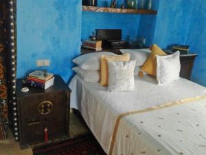 a blue bedroom with a bed and a mirror at Jardim dos Aloés, Unique B&B - Casa de Charme in Ilha de Moçambique