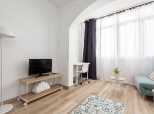 sala de estar con TV y sofá azul en Navy by Seaside Homes en Castelldefels