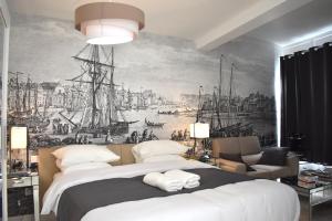 a bedroom with a large bed with a painting on the wall at Villa Castel Chambres d'hôtes B&B in Dieppe