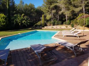 une piscine avec deux chaises longues et une piscine dans l'établissement Villa Eléonore, à Saint-Cyr-sur-Mer
