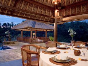 an outdoor dining area with a table and chairs at Villa Santai in Ubud
