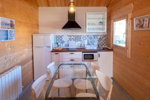 uma cozinha com uma mesa de vidro e electrodomésticos brancos em Villas de Arribes em Aldeiadávila da Ribera
