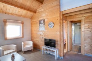 sala de estar con paredes de madera y TV de pantalla plana. en Villas de Arribes, en Aldeadávila de la Ribera