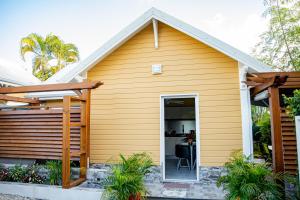 a home with a yellow house at Villas Ixora in Sainte-Anne