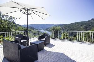 - une terrasse avec 2 chaises et un parasol dans l'établissement Sousa Horizonte - Louredo, à Vieira do Minho