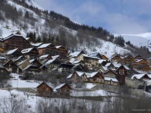a group of houses covered in snow on a mountain at VAUJANYLOCATIONS - Chalet De Marie in Vaujany
