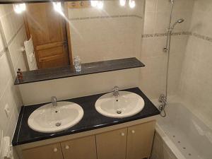 a bathroom with two sinks and a mirror and a tub at VAUJANYLOCATIONS- Chalet du Verney in Vaujany +25 photos