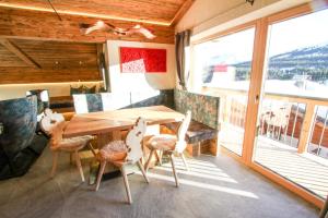 - une salle à manger avec une table et des chaises en bois dans l'établissement Enzian Wohnung B, à Königsleiten