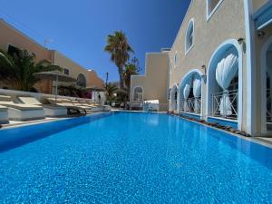 una grande piscina blu accanto a un edificio di Dioskouri Art Villas a Kamari